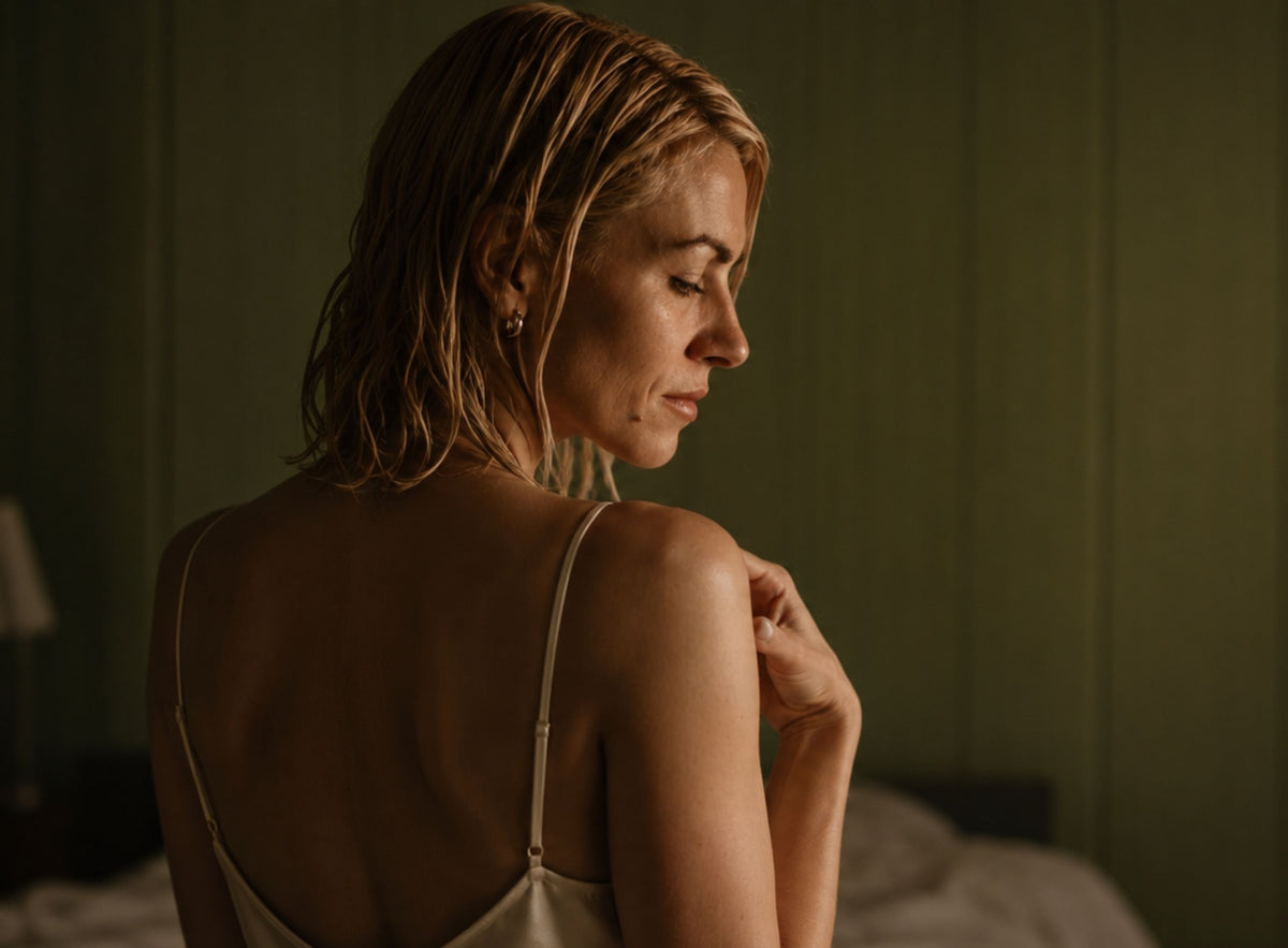 A woman with wet blonde hair is shown from behind in profile
