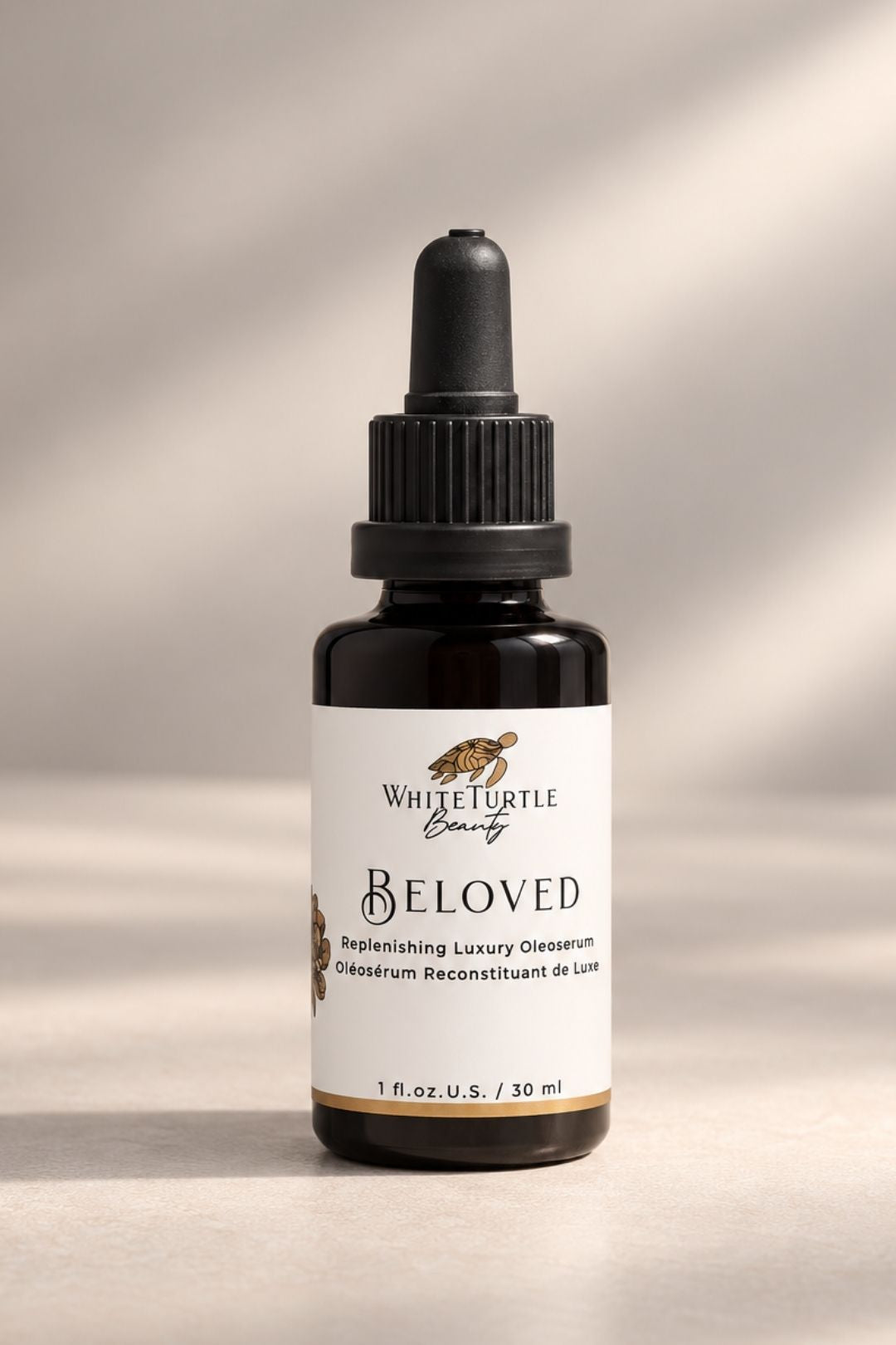 A bottle of White Turtle Beauty BELOVED replenishing Luxury Oleoserum se in beige background