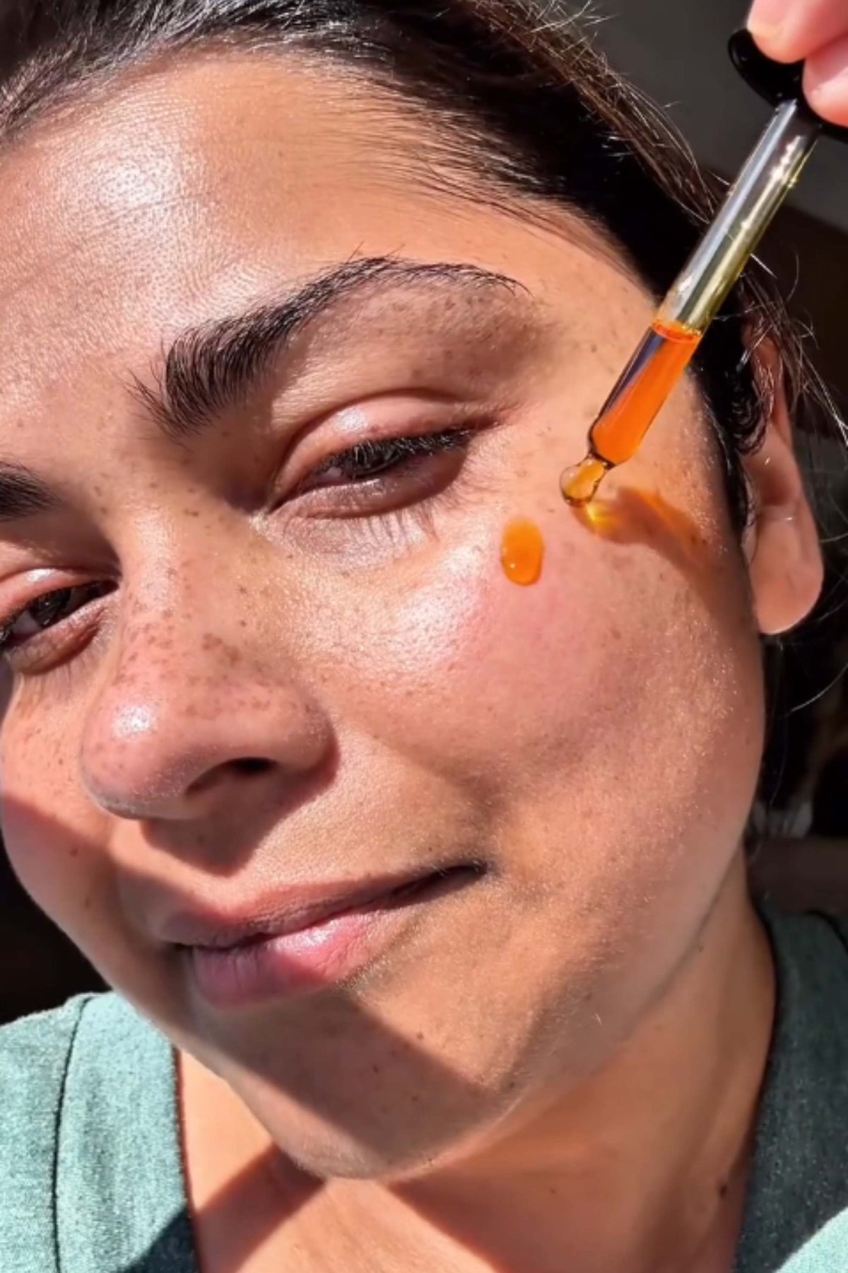 Woman applying CHERISHED antioxidant serum to prematurely aged skin