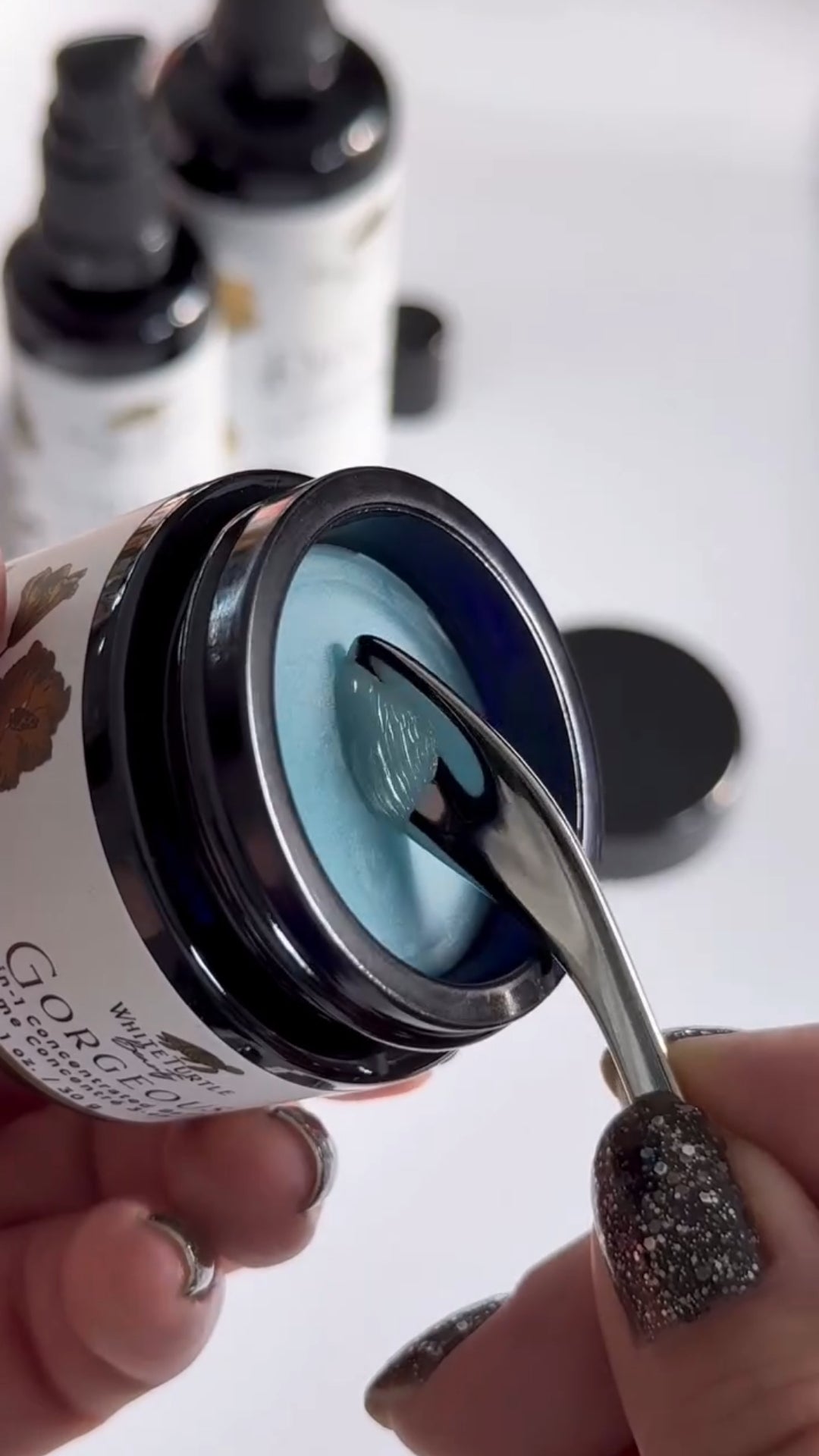 Person using a spoon to scoop blue GORGEOUS 3-in-1 Concentrated Balm