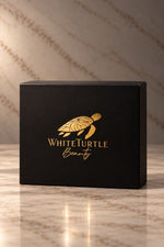 A black gift product box with a gold turtle logo and the text 'White Turtle Beauty' 