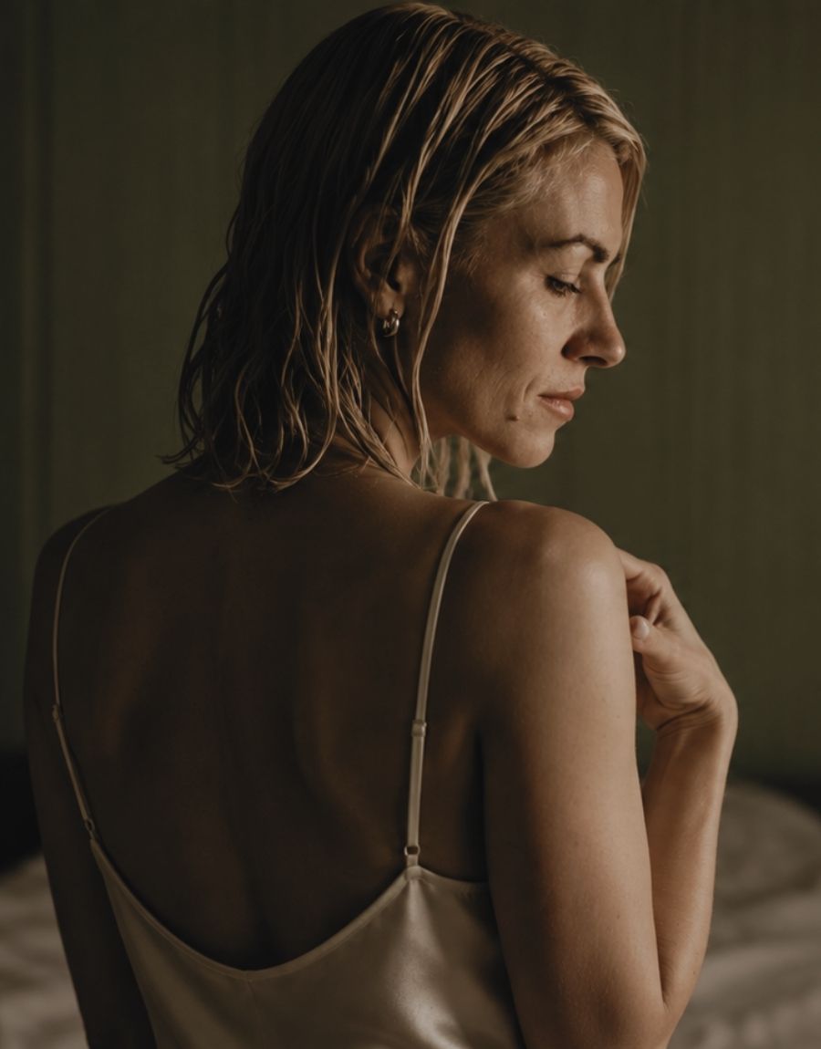 A woman with wet, damp blonde hair is shown from behind