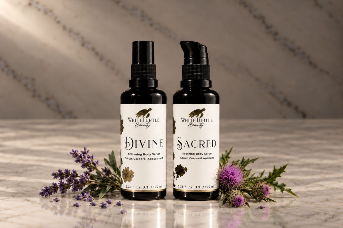 Two White Turtle Beauty body serum bottles labeled Divine and Sacred, 