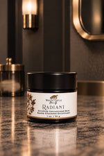 A jar of White Turtle Beauty Radiant Enriching Concentrated Balm sits on a polished dark marble countertop