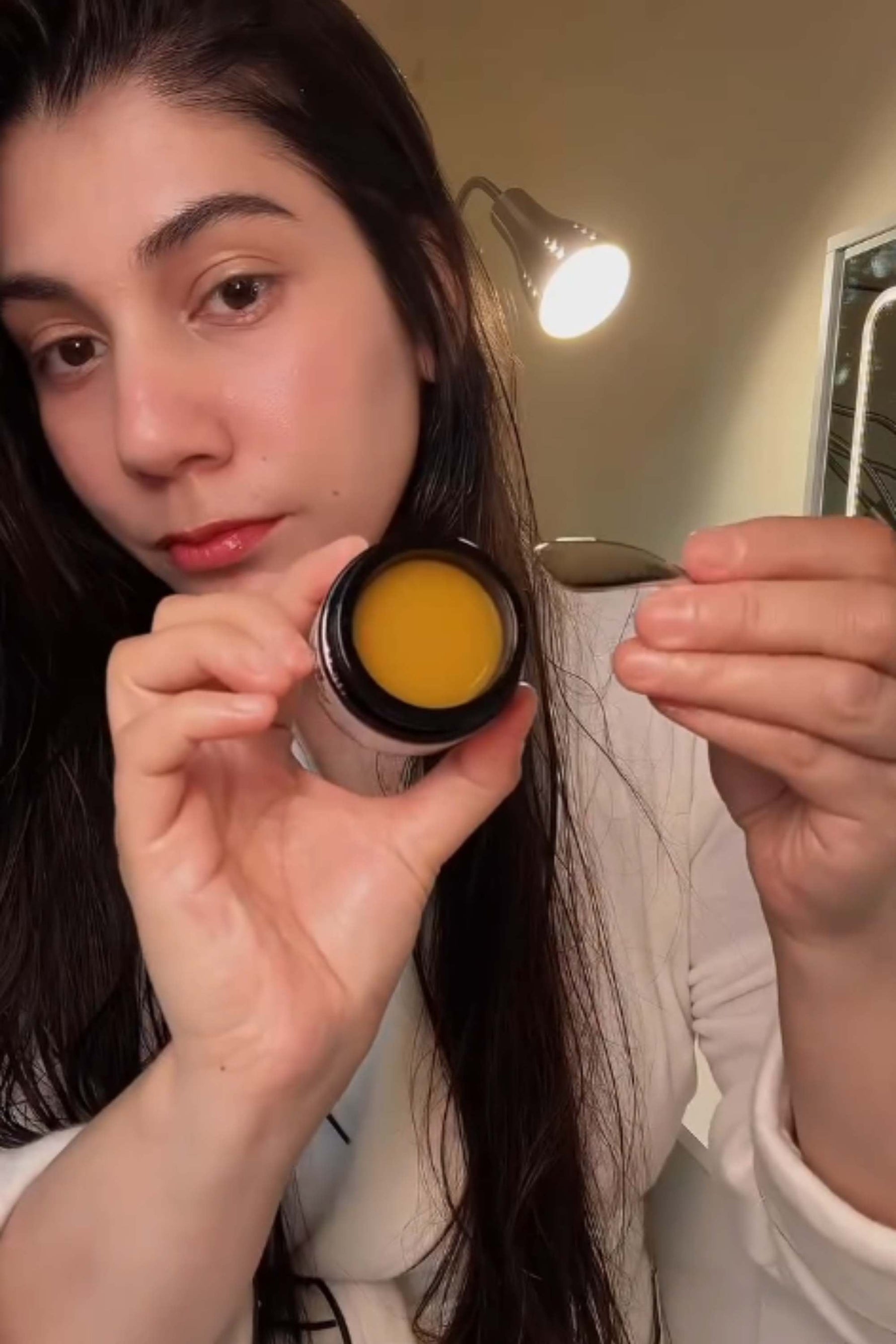 Woman scooping RADIANT concentrated balm for dehydrated and dry skin
