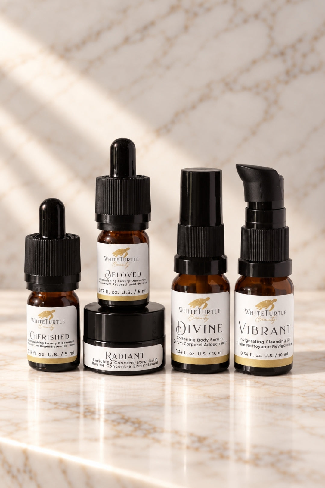 Four White Turtle body care products arranged on a light marble surface: