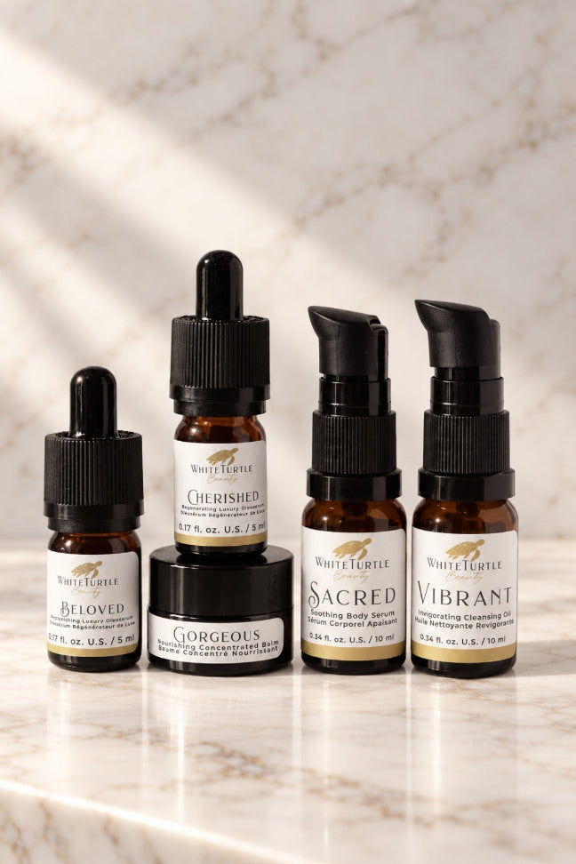 Four White Eagle skincare bottles and jars arranged on a light marble surface with a marble wall behind them.