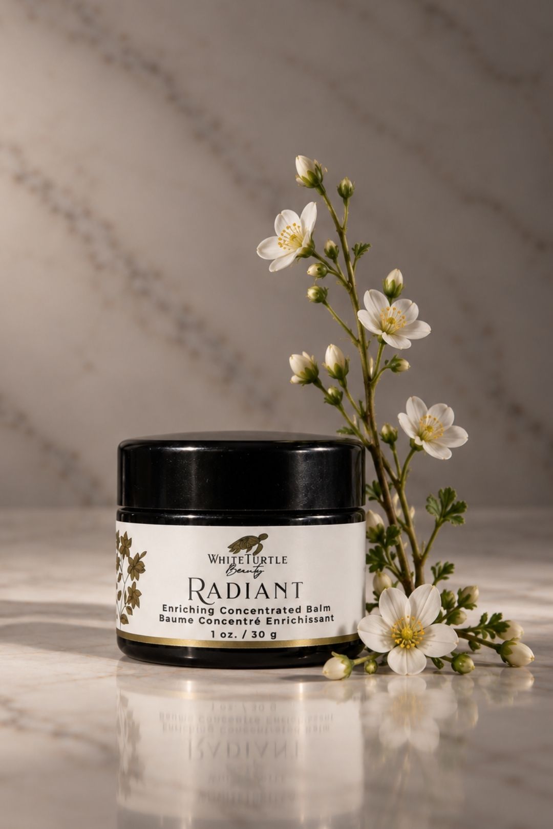 A jar of White Turtle Beauty Radiant Enriching Concentrate Balm sits on a polished marble surface
