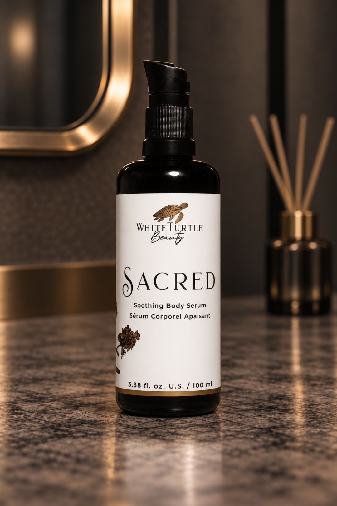 A bottle of White Turtle Beauty Sacred Soothing Body Serum standing on a dark marble countertop 