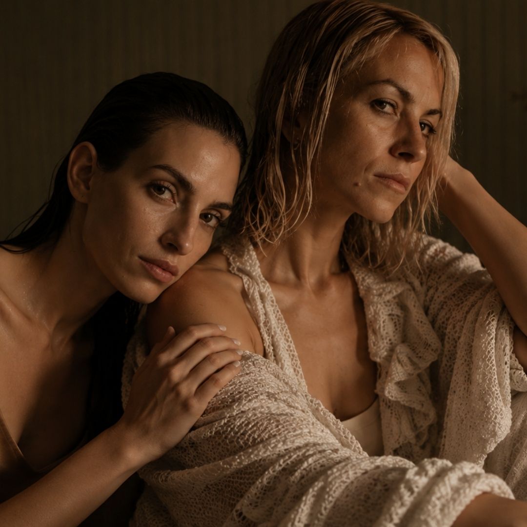 Two women in a dimly lit, intimate setting. 