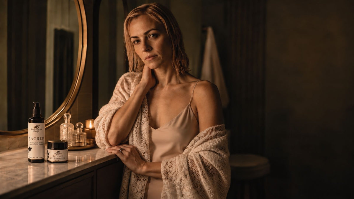 A woman in a beige slip dress and textured cream robe with White Turtle Beauty products
