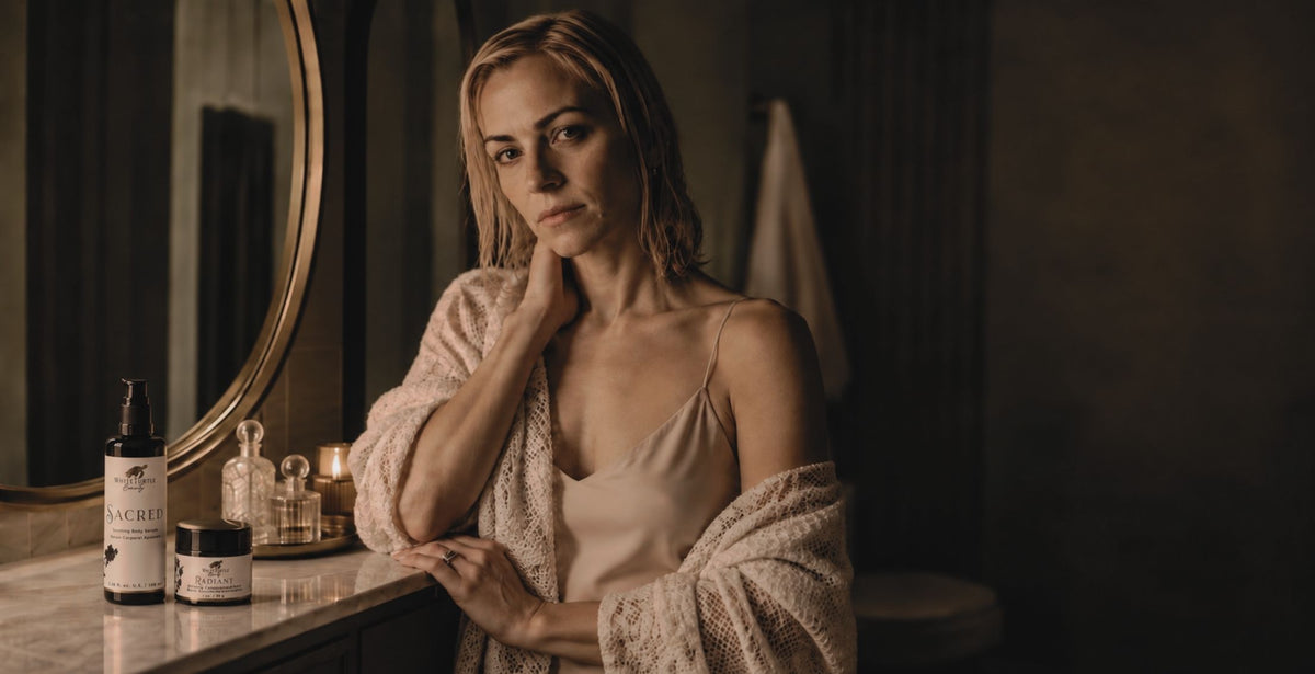 A woman in a bathroom setting with White Turtle Beauty products