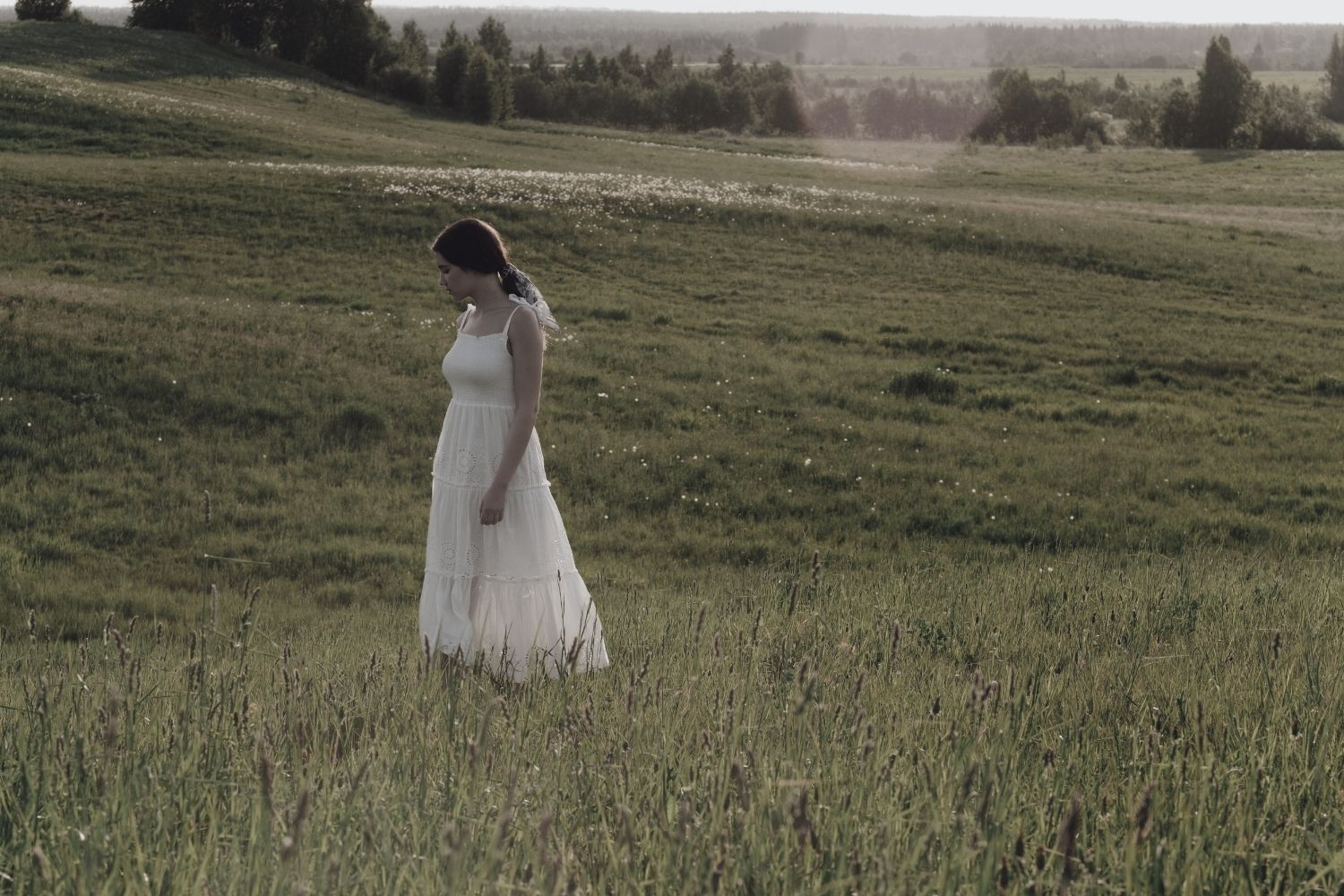 Woman meditating in a grass summer field